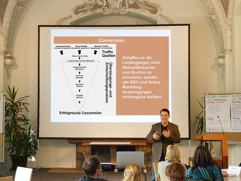 Ortwin Oberhauser giving a talk at the 2013 partner day of the Styrian nature parks, a conversion chart on the screen